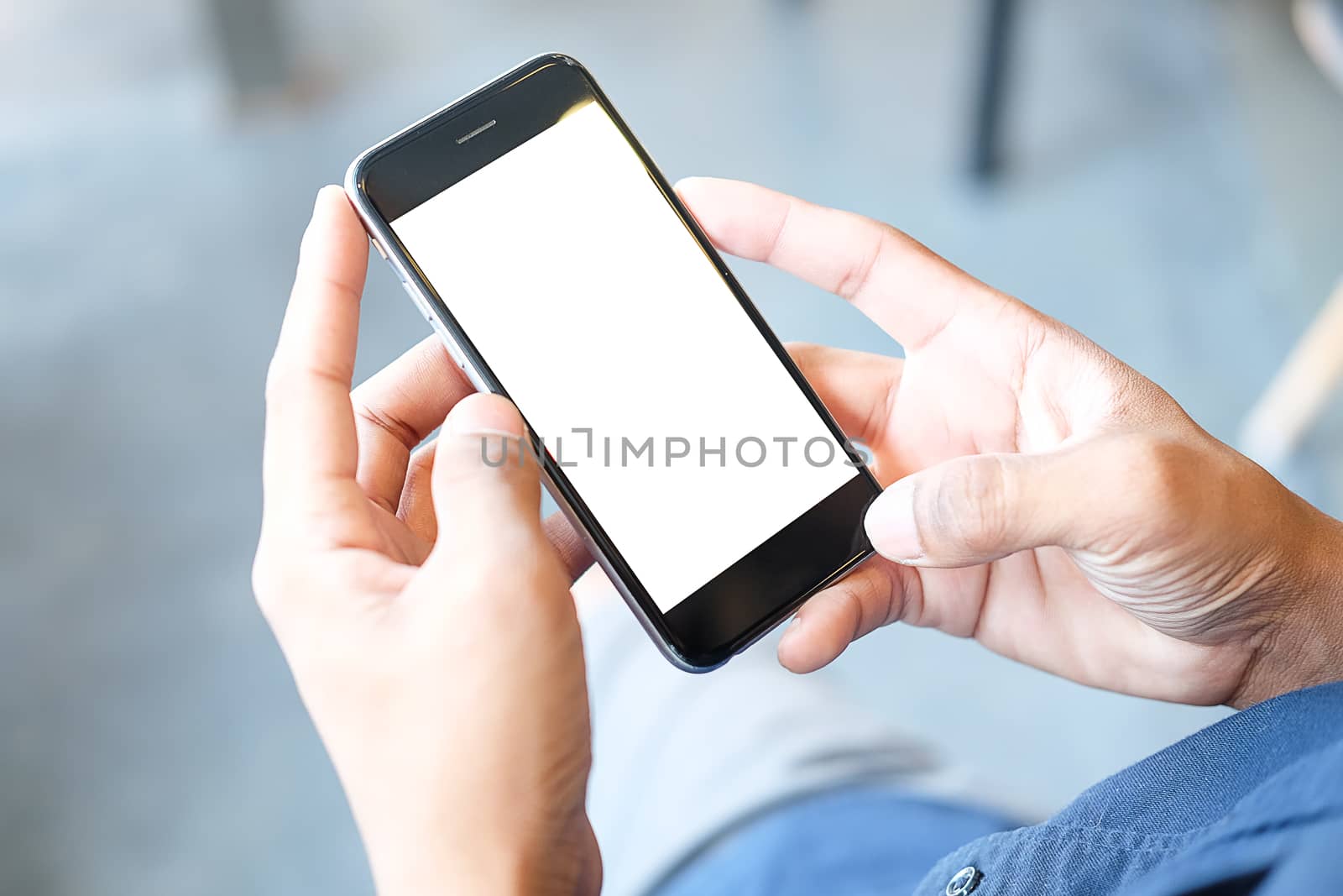 Cropped shot view of man hands holding smart phone with blank copy space screen for your text message or information content, female reading text message on cell telephone during in urban setting. 