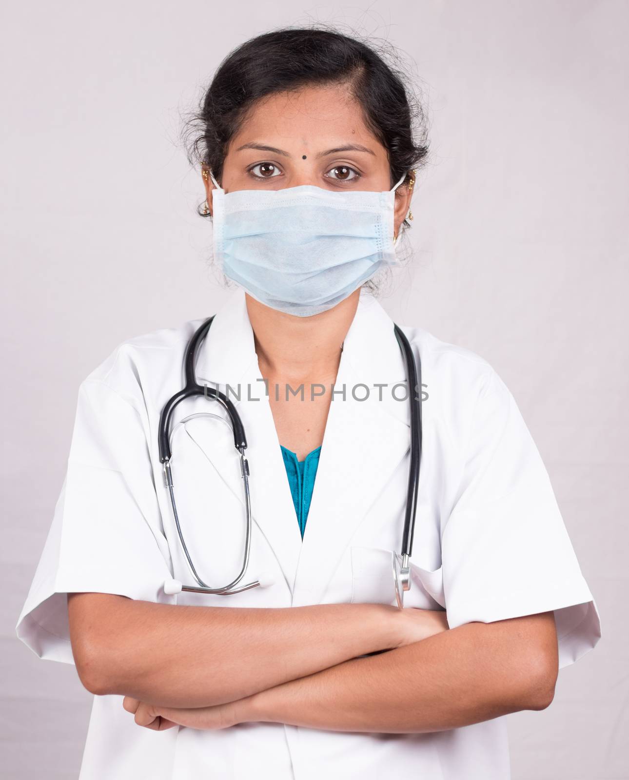 Portrait of Confident woman or female doctor wearing medical face mask standing with crossed arms on isolated background
