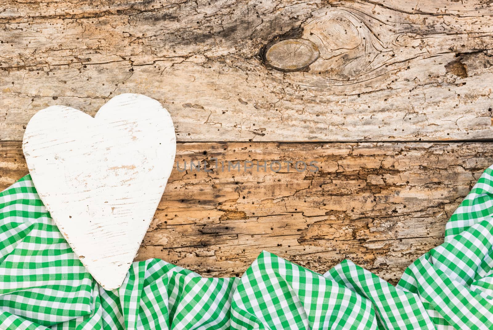 Rustic background for mothers day with white heart and green fabric
