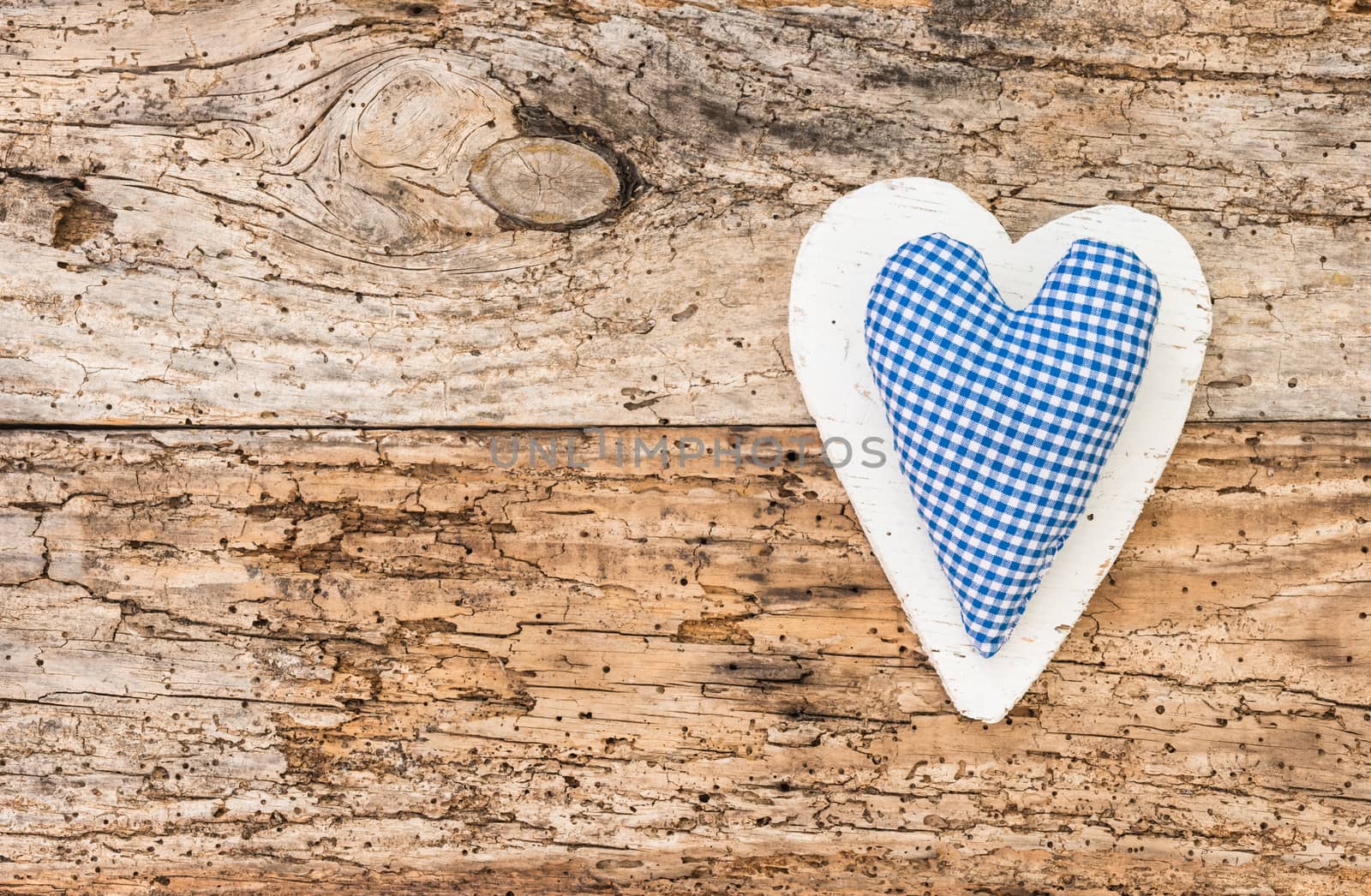 Blue rustic fabric heart on vintage wooden background with copy space