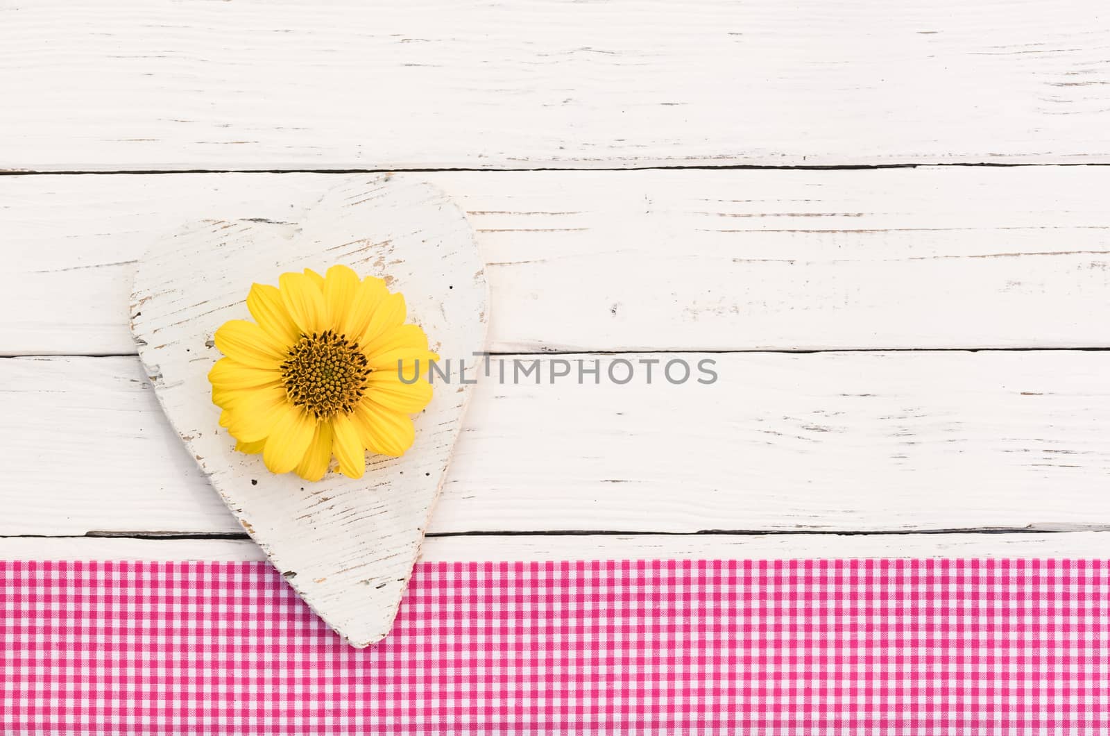 Rustic white wooden heart on white background with yellow flower and copy space