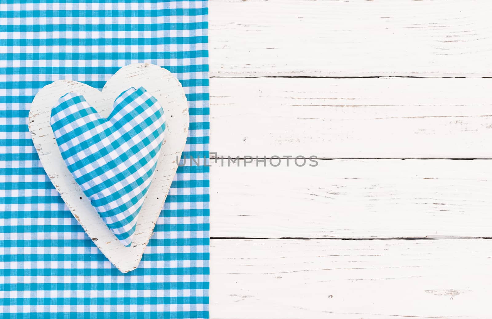 Rustic light blue fabric heart on white wood background with copy space