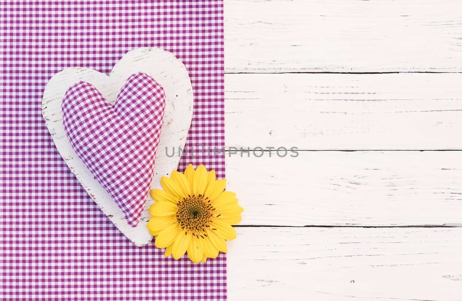 Fabric purple heart with yellow blossom on white wood with copy space