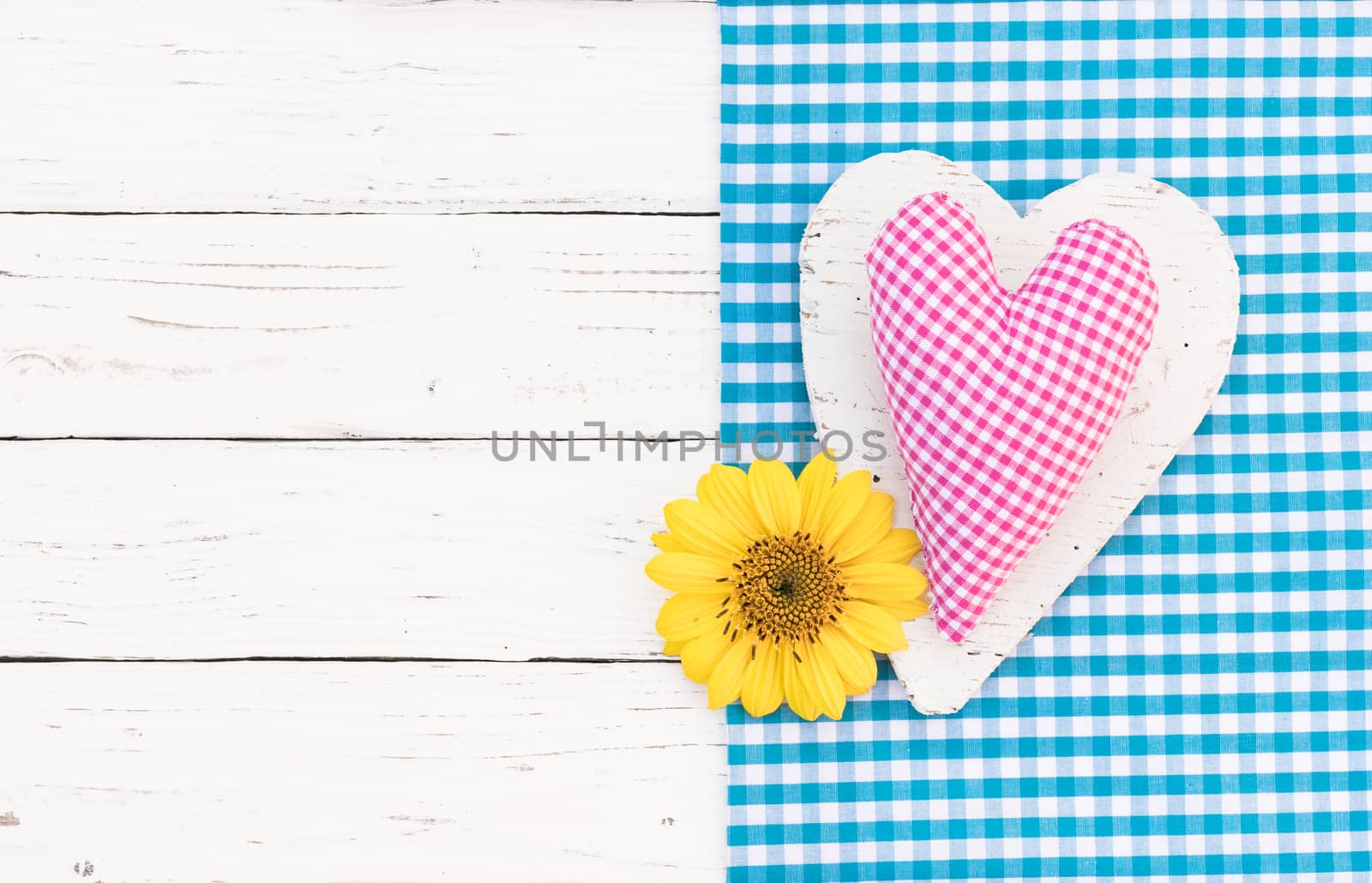 Romantic pink heart with yellow blossom on white wooden background with copy space