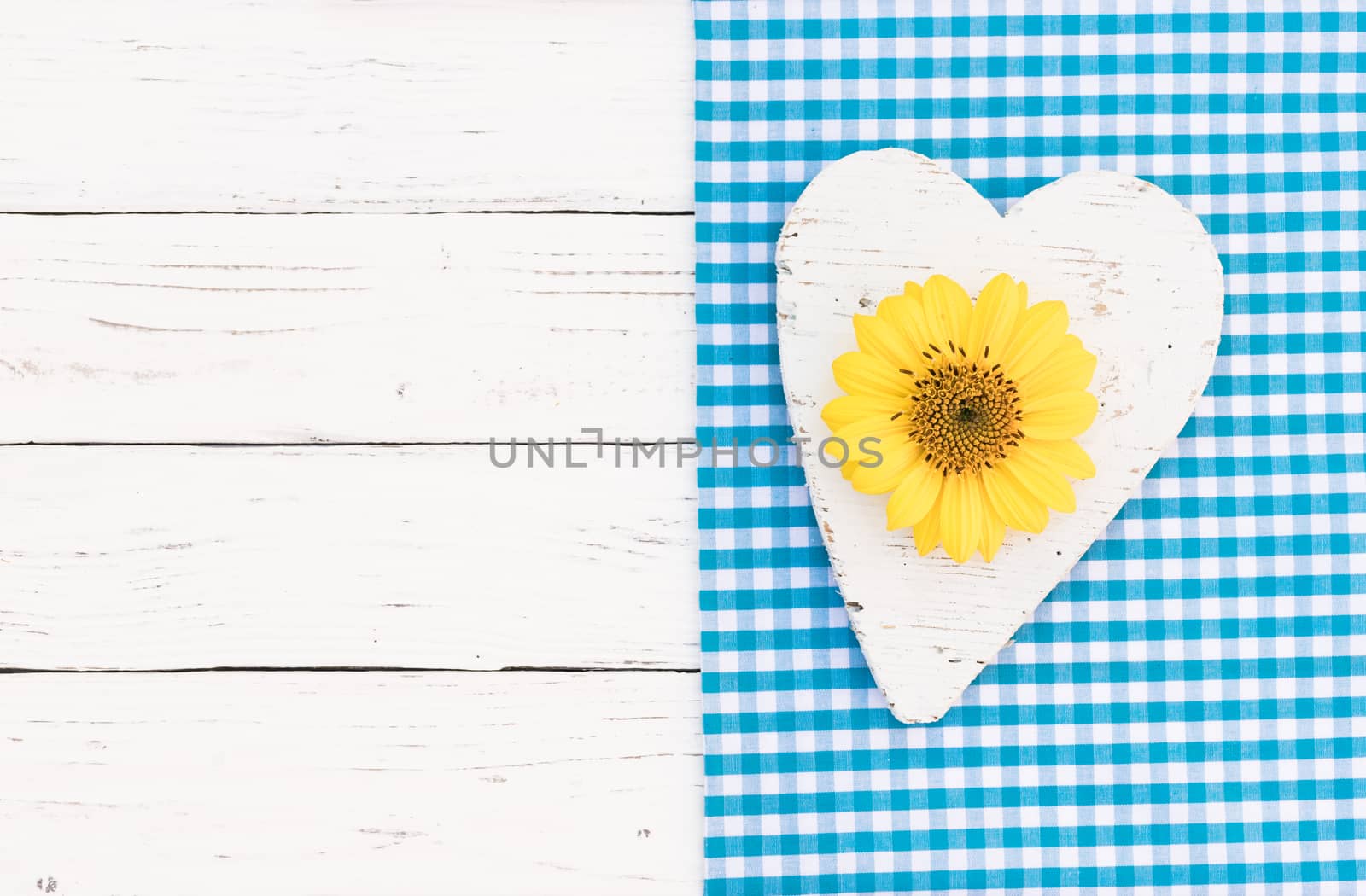 Romantic greeting card with white wooden heart and yellow blossom