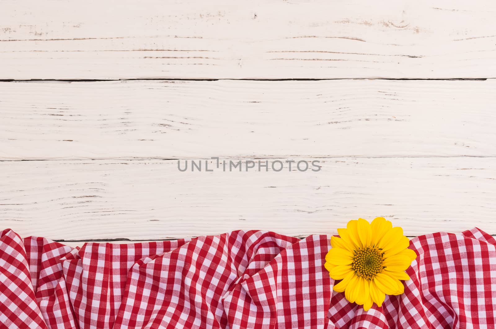 White wood table with red fabric and flower with copy space