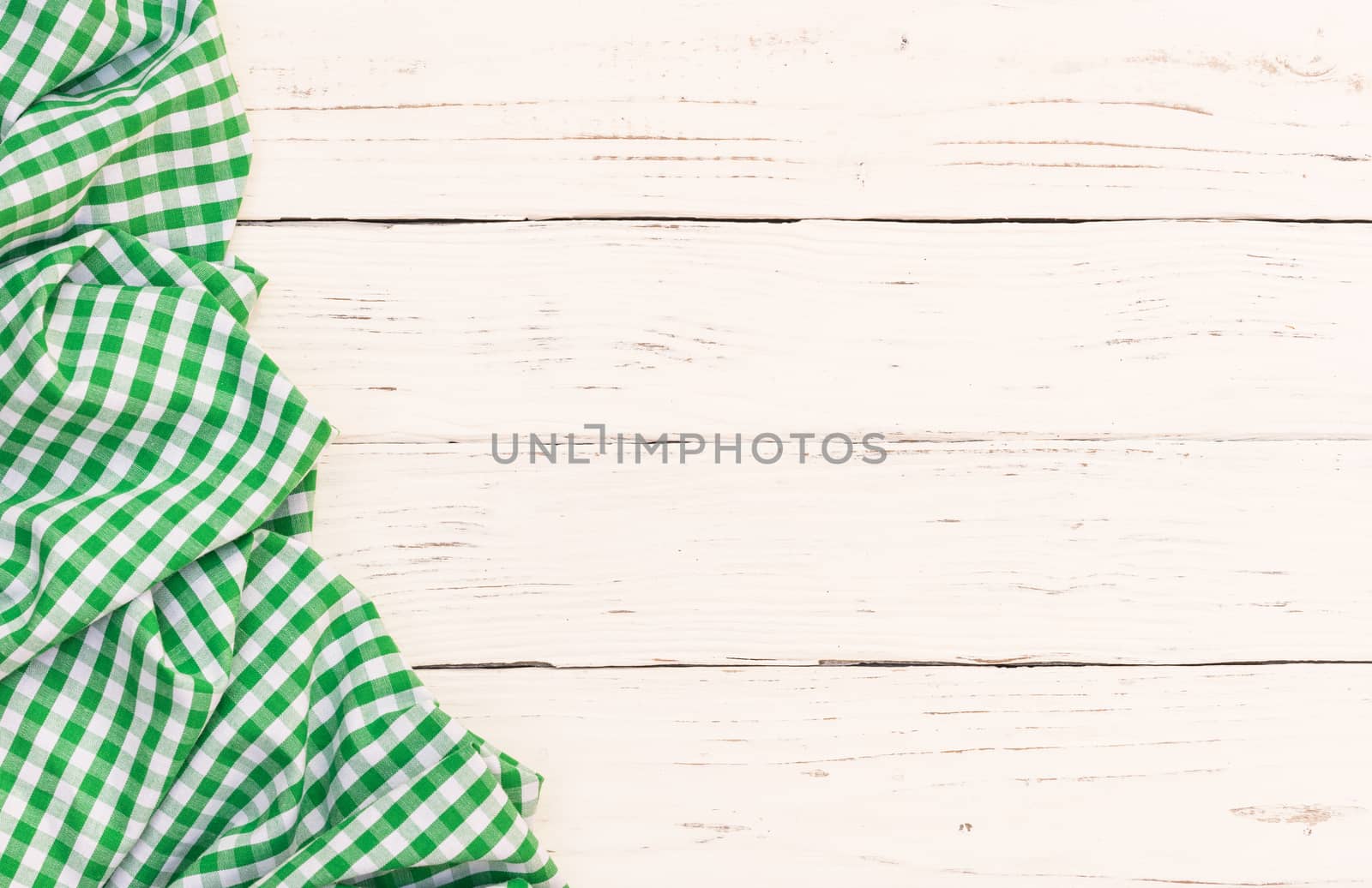 White wooden table background with rustic green checkered tablecloth, high angel view

