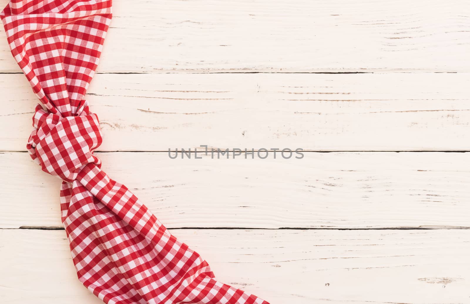 White wooden table background with red knotted tablecloth and copy space