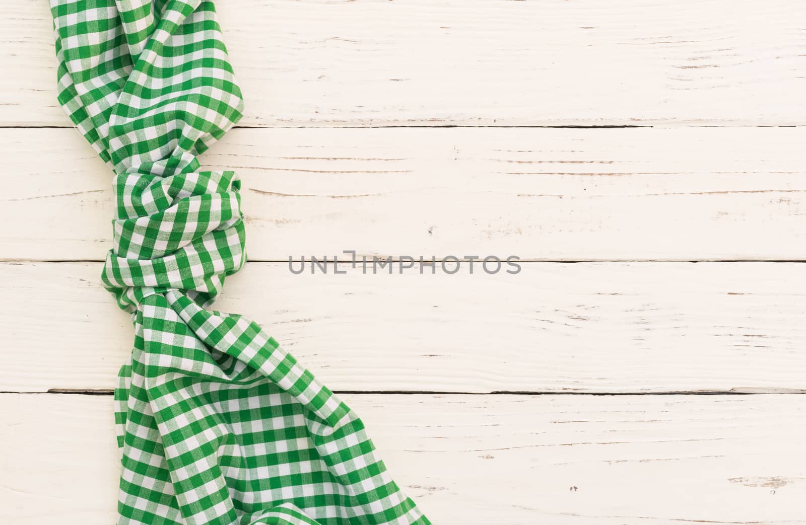 White wooden table background with green checked tablecloth, top view