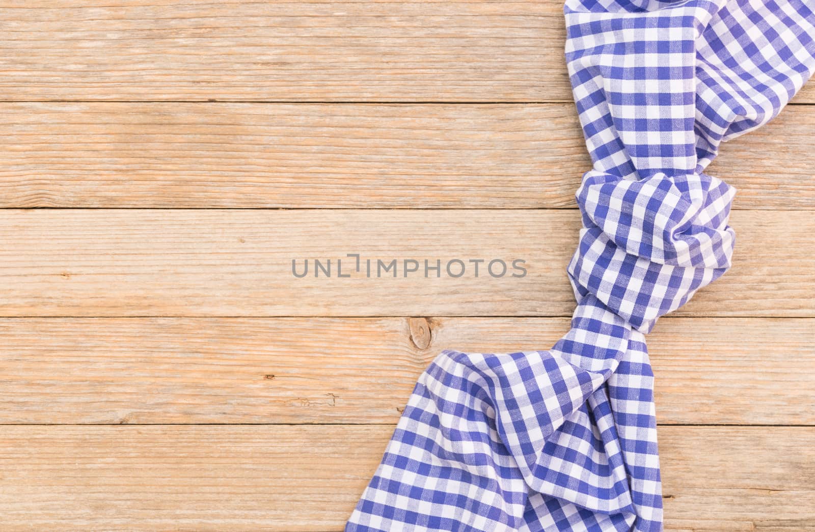Blue tablecloth on wooden table background, top view with serving size