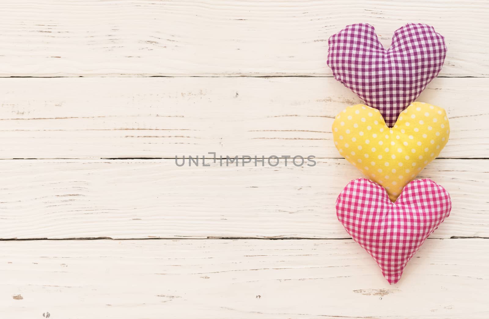 Valentine background with fabric hearts border on white wood and copy space