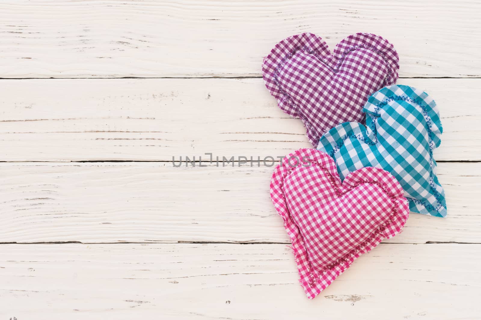 Composition of colorful hearts on white wooden background with copy space