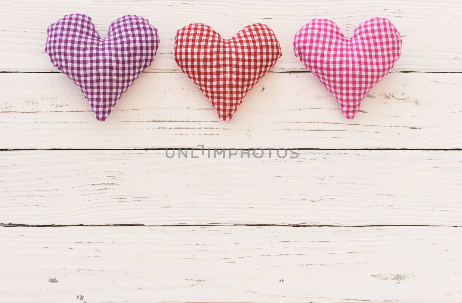 Valentine background with fabric hearts border on white wood and copy space