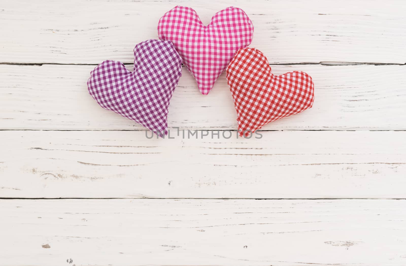 Valentine background with fabric hearts border on white wood and copy space
