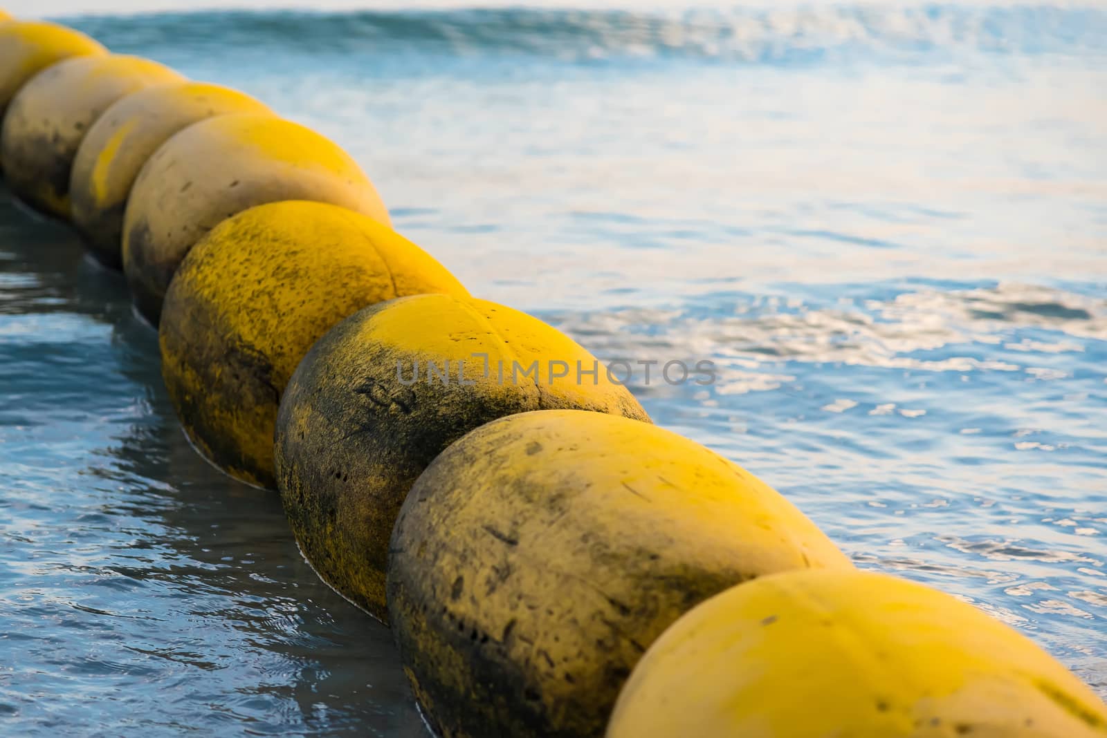 Yellow buoyancy on the beach, sign warning dangerous.