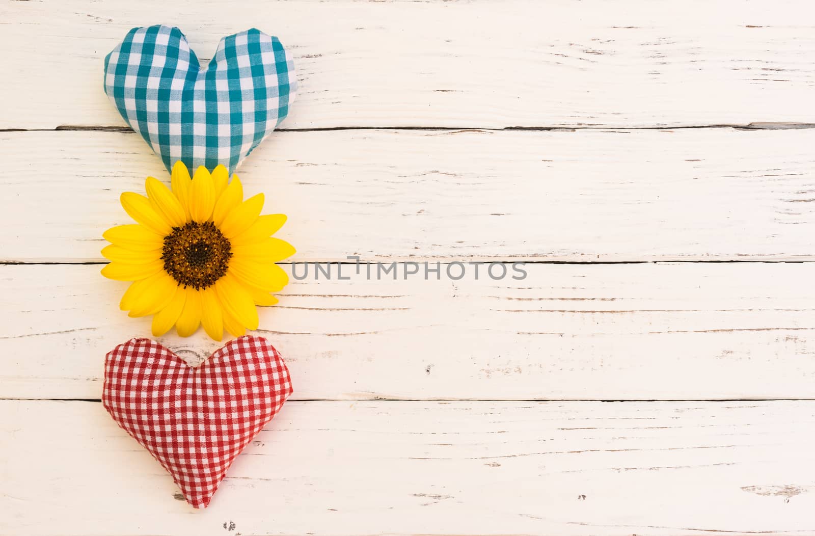 Two love hearts with flower on white wooden background with copy space