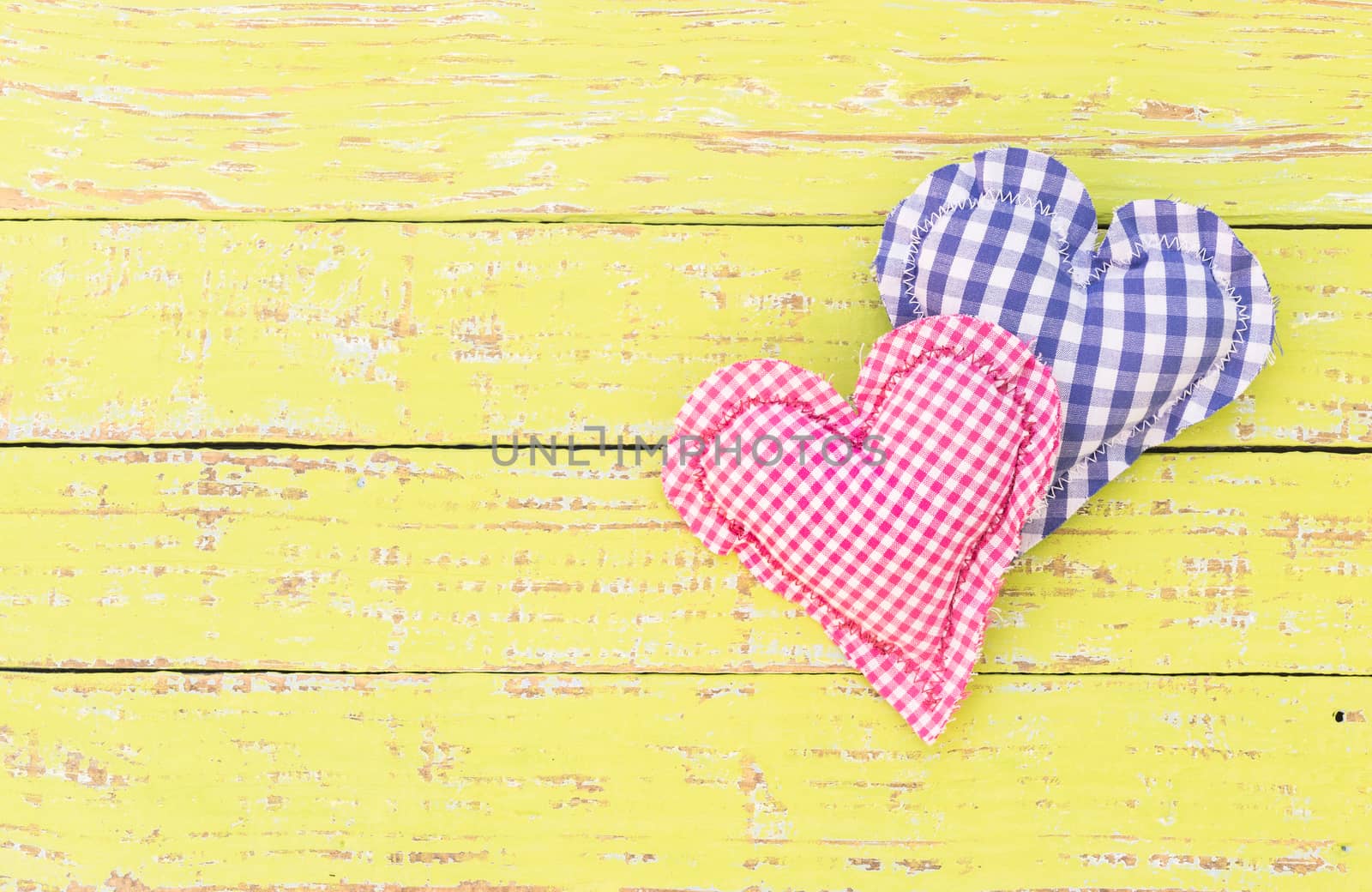 Blue and pink heart on yellow rustic wood with copy space