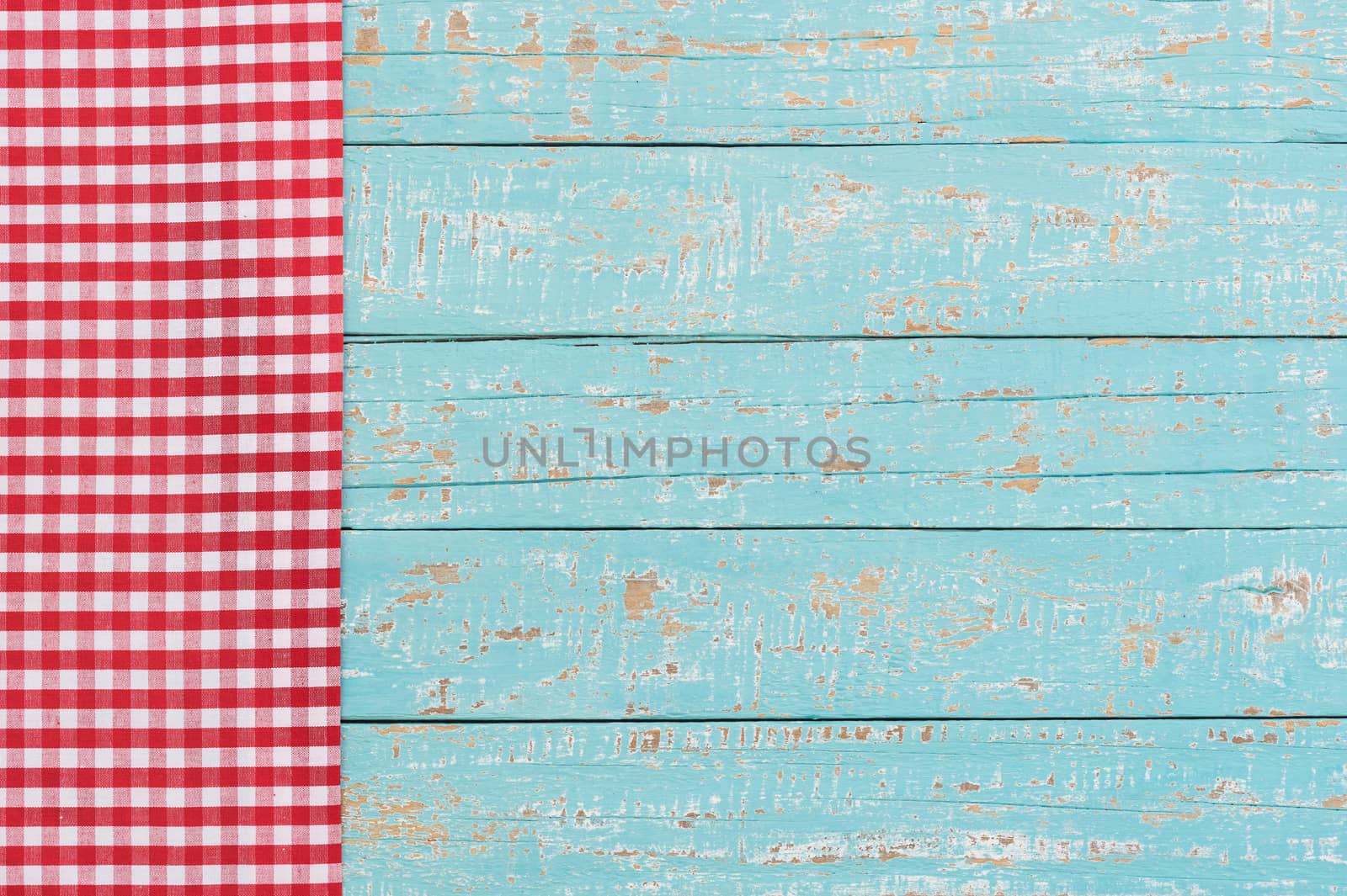 Rustic kitchen wood table background with red checked tablecloth