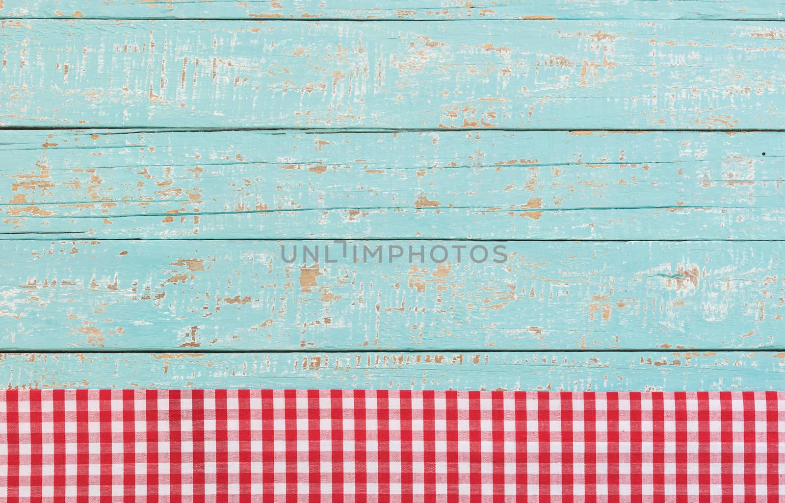 Red checked tablecloth on blue wooden kitchen table background