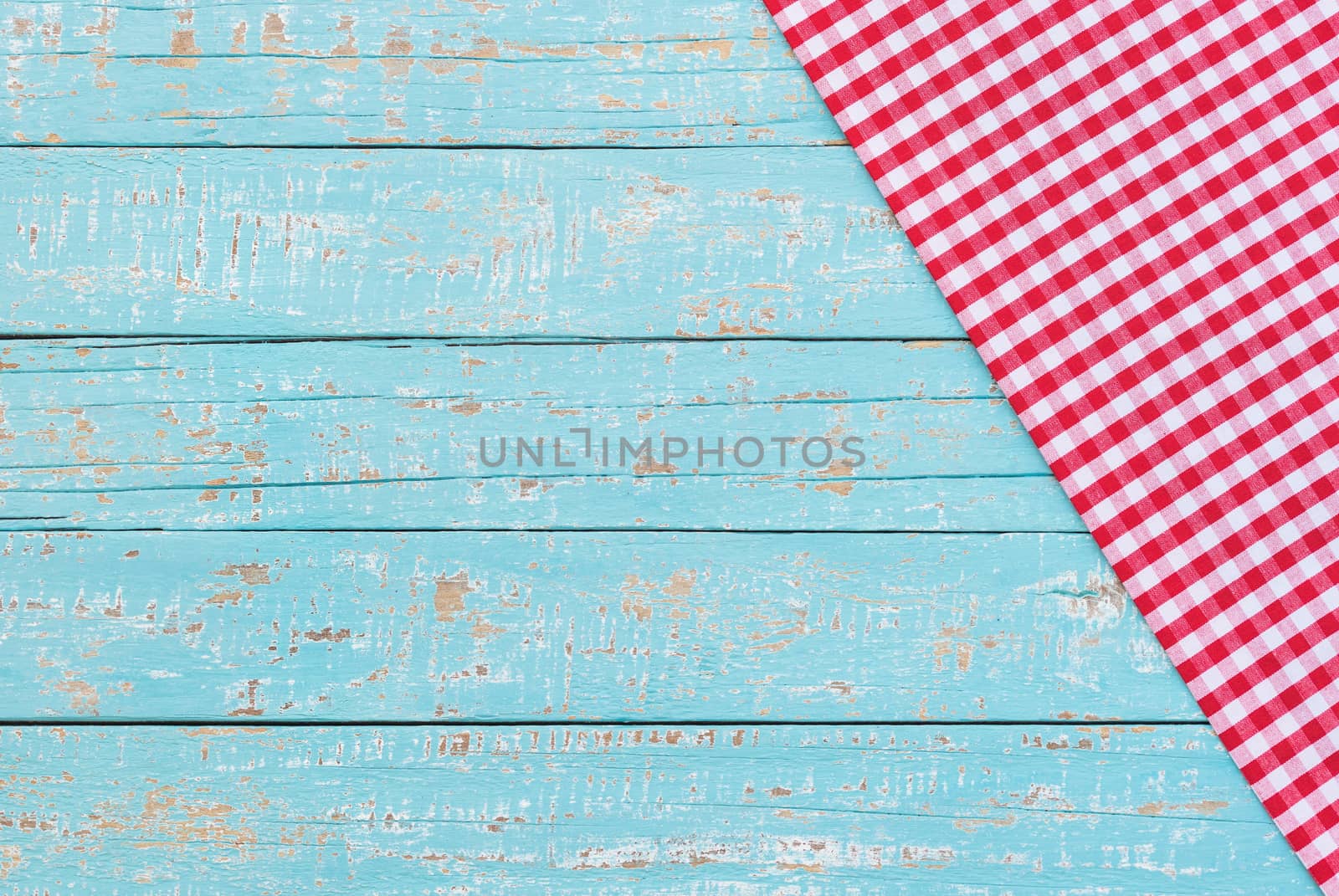 Rustic kitchen wood table background with red checked napkin
