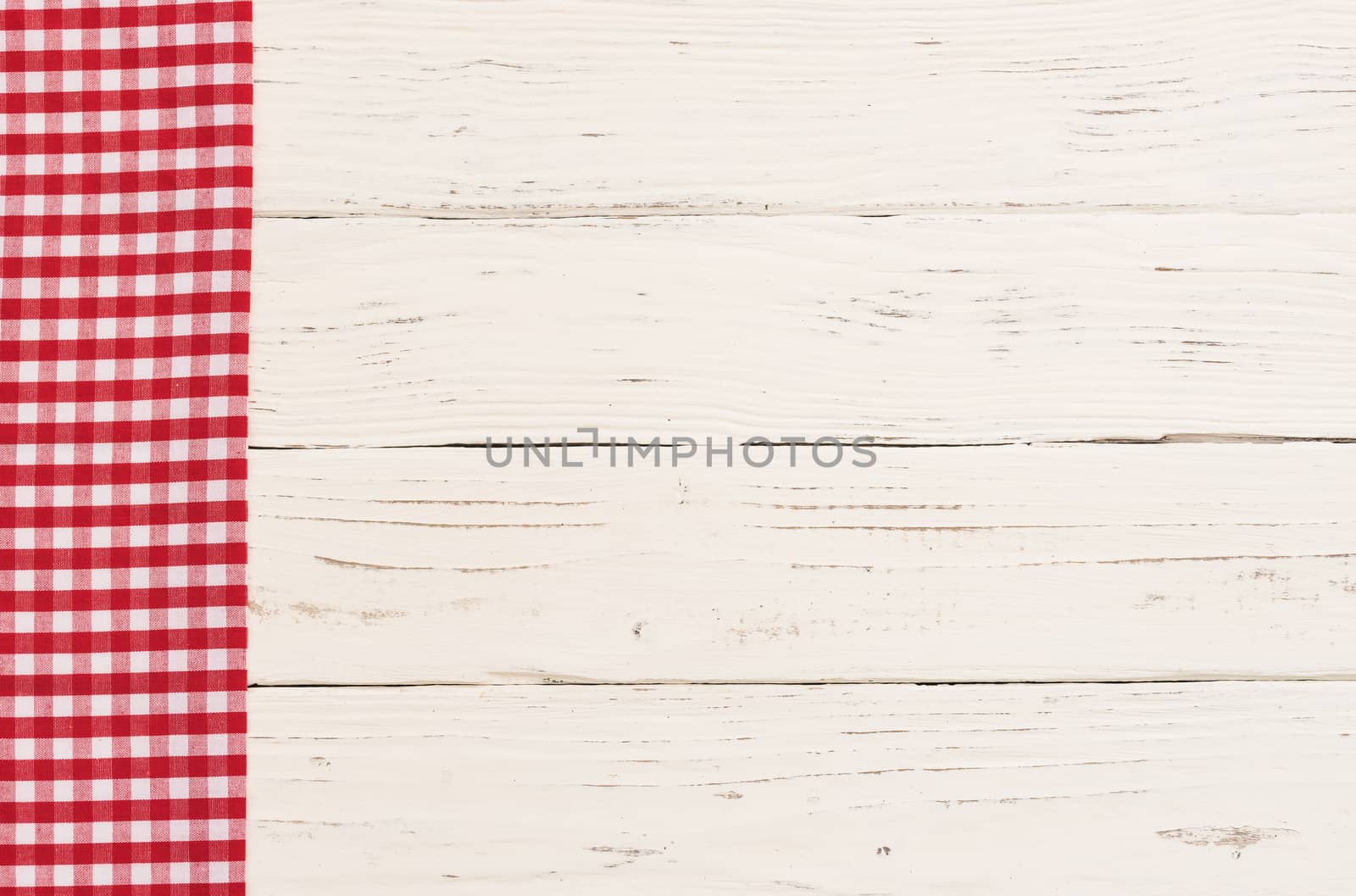 Red checkered napkin on white wooden kitchen table background