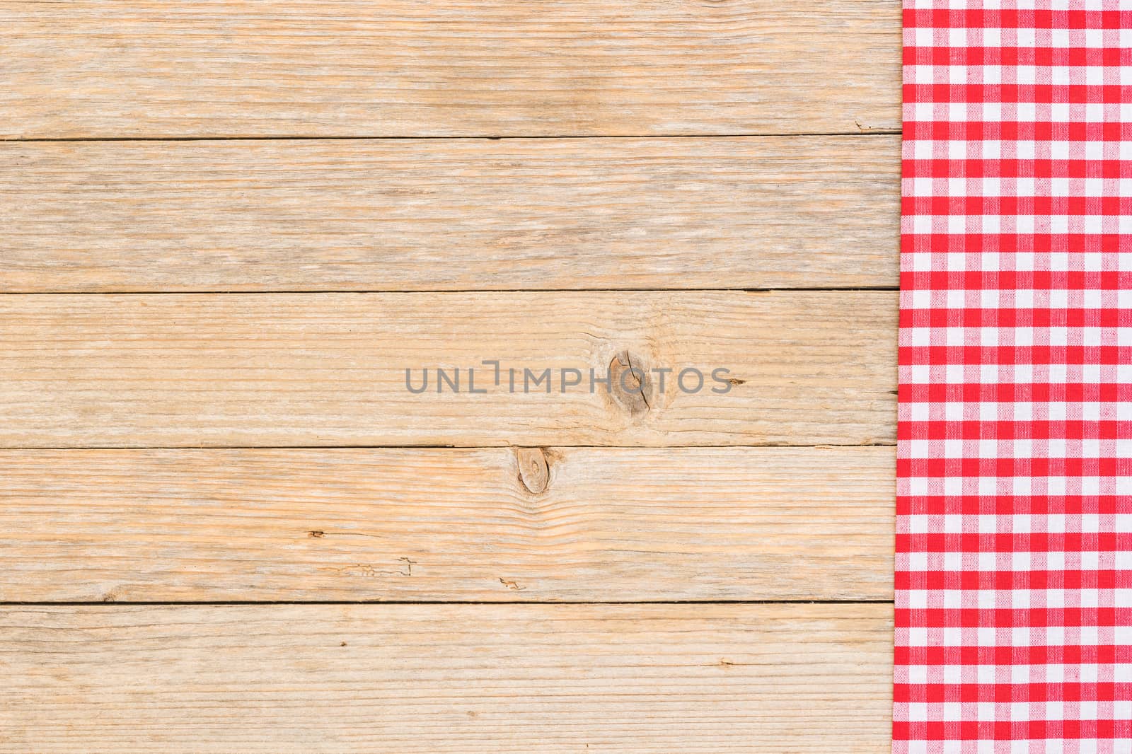 Red checkered tablecloth on rustic wooden table background