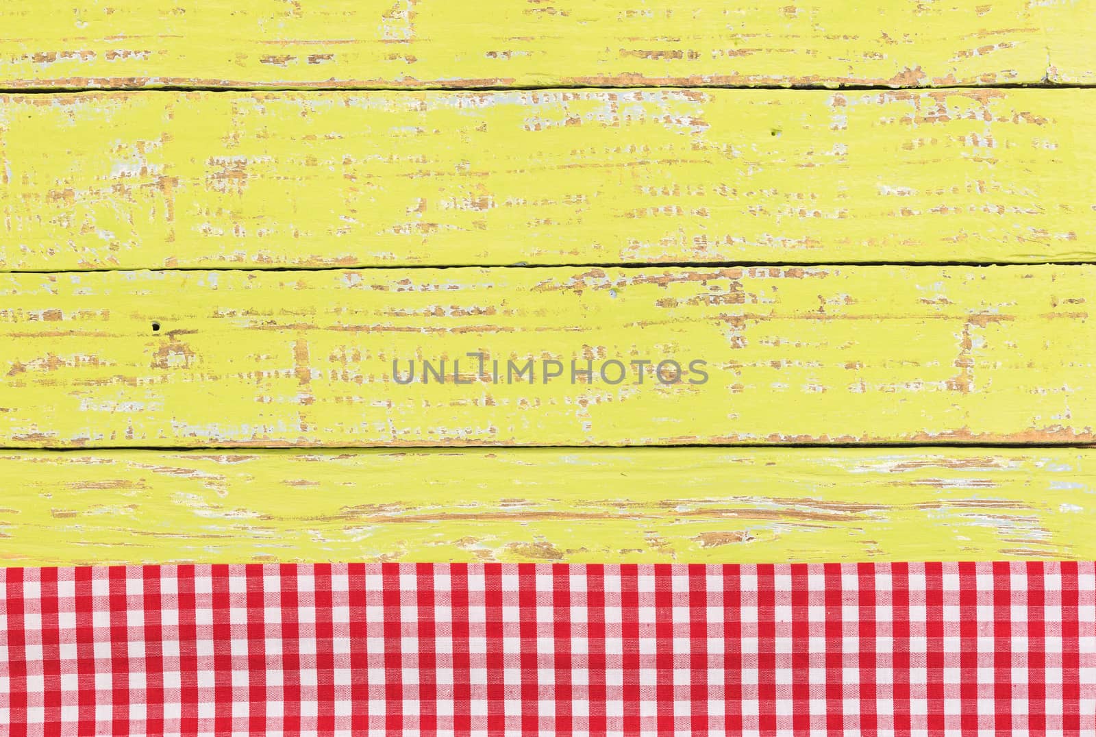 Red checkered tablecloth on rustic green wooden table background