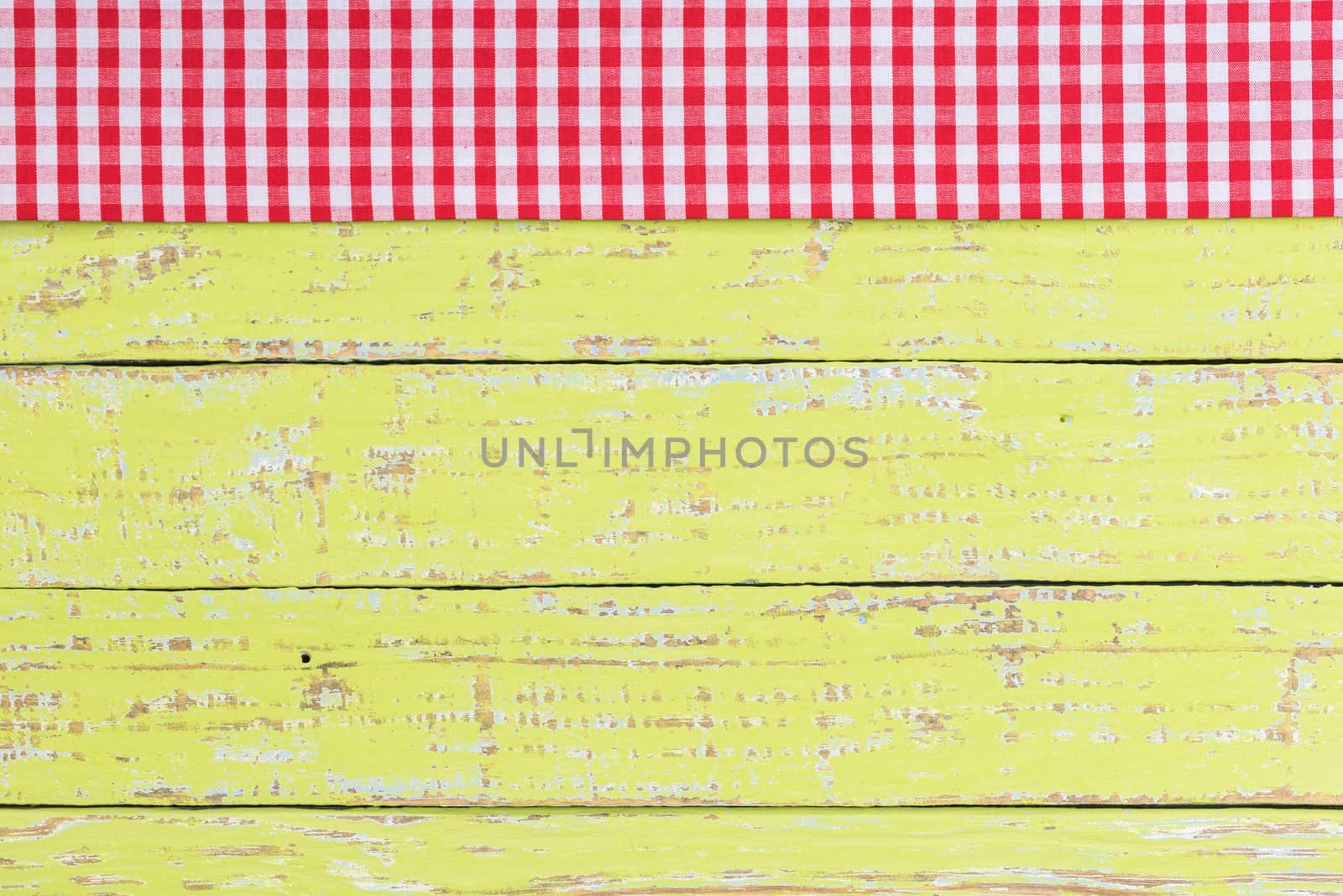 Rustic green kitchen table background with red checked tablecloth