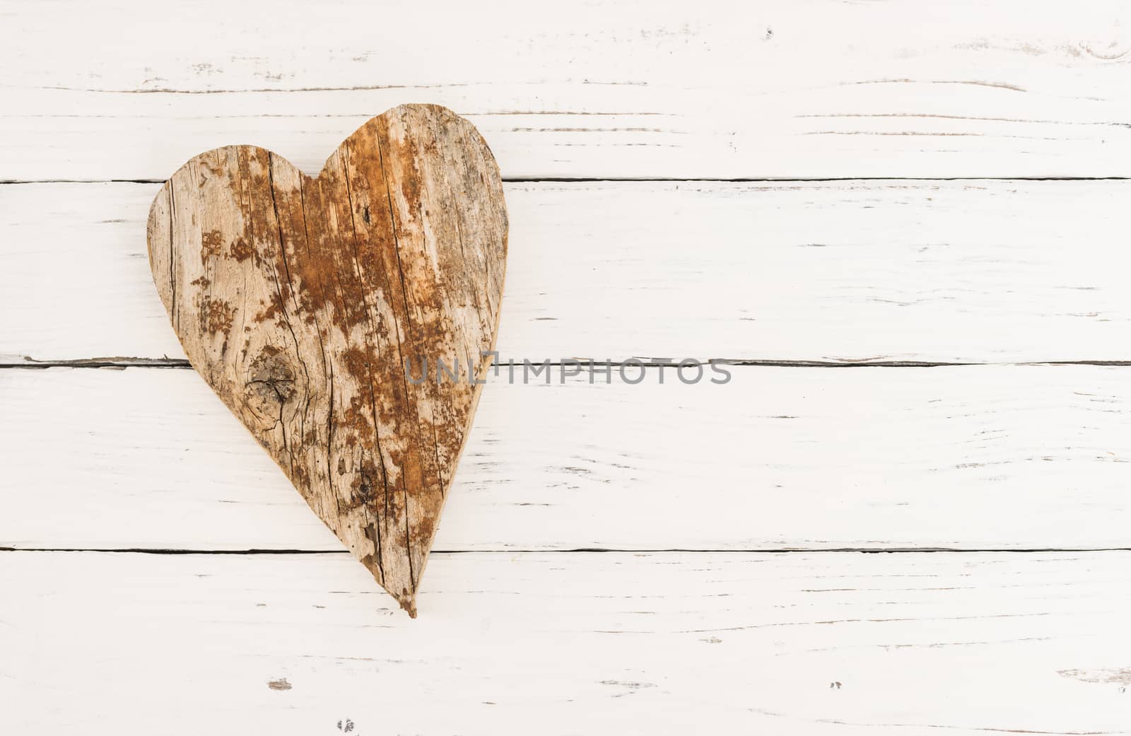 Brown natural wooden heart shape on white wood with copy space