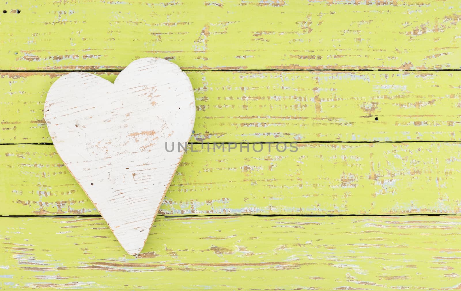 Rustic white heart on colored wooden background with copy space