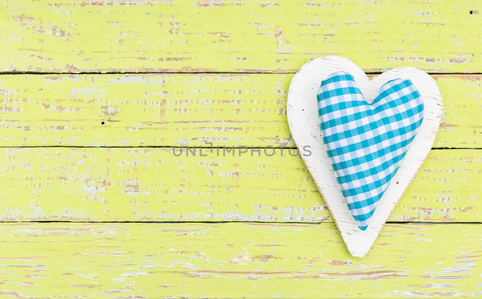 Light blue rustic heart on colored wooden background with copy space