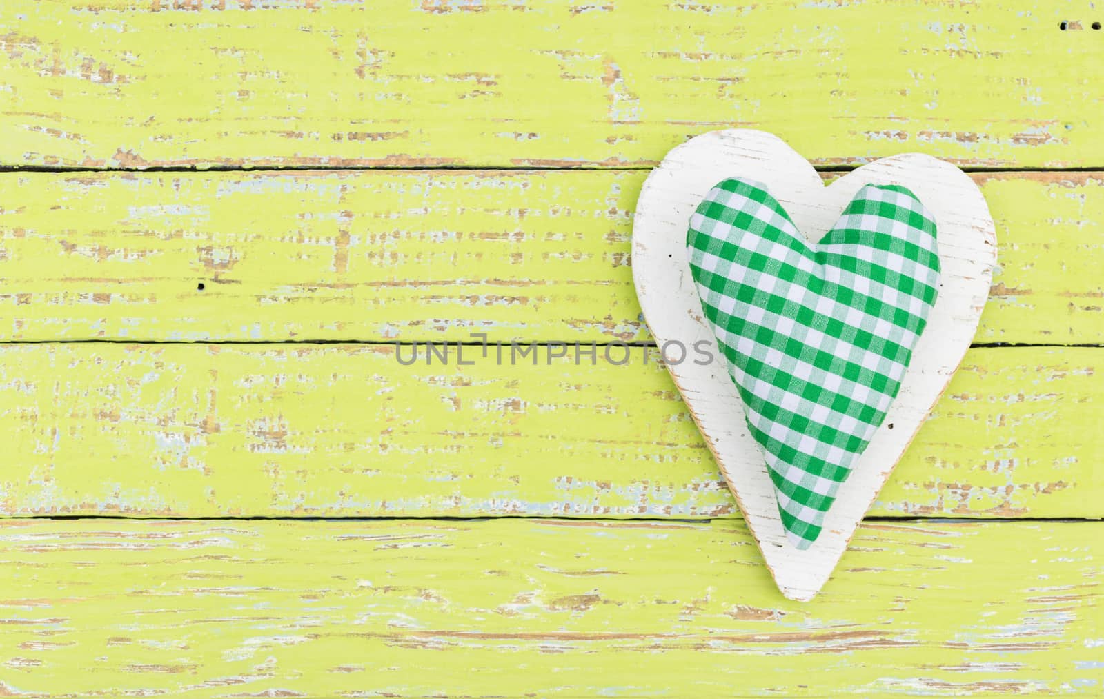 Green fabric heart on wooden background with copy space