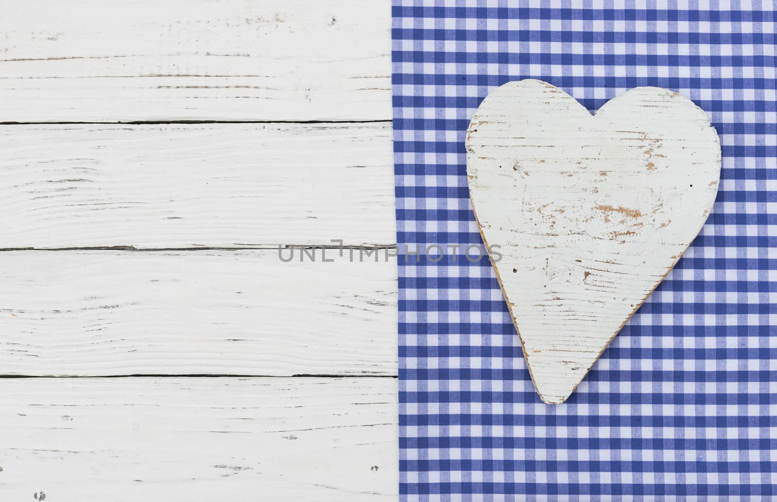 White wooden heart on blue textile border and wood with copy space