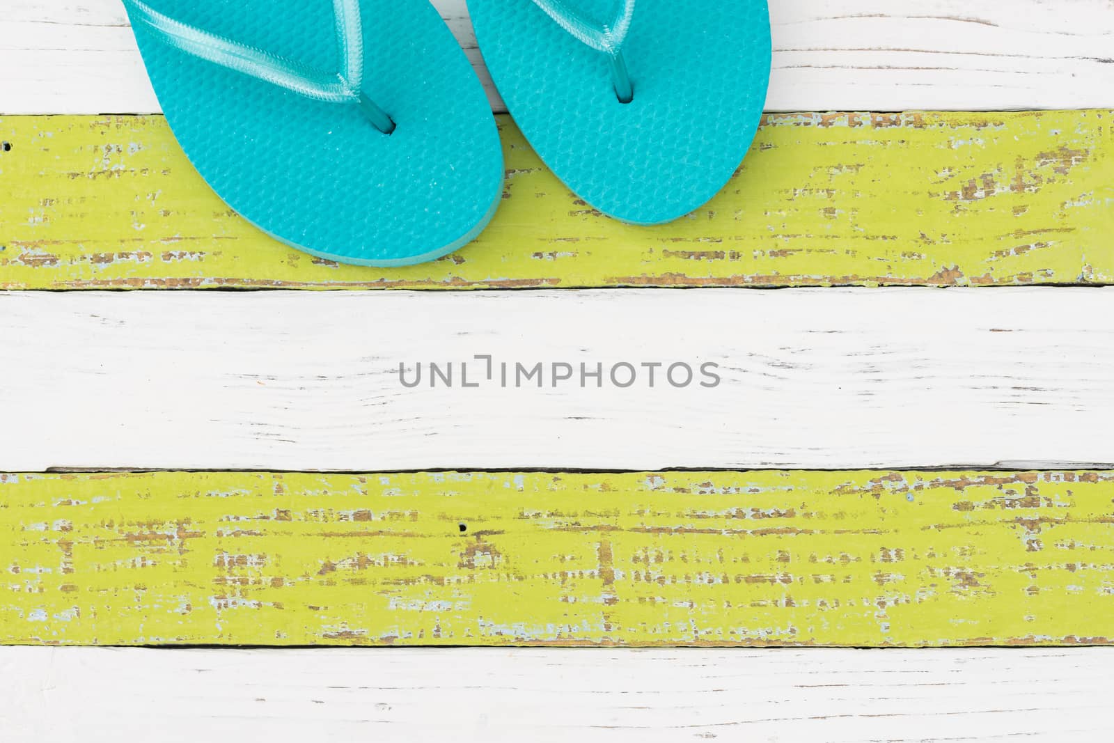 Summer vacation travel concept background with turquoise beach sandals on colored wood