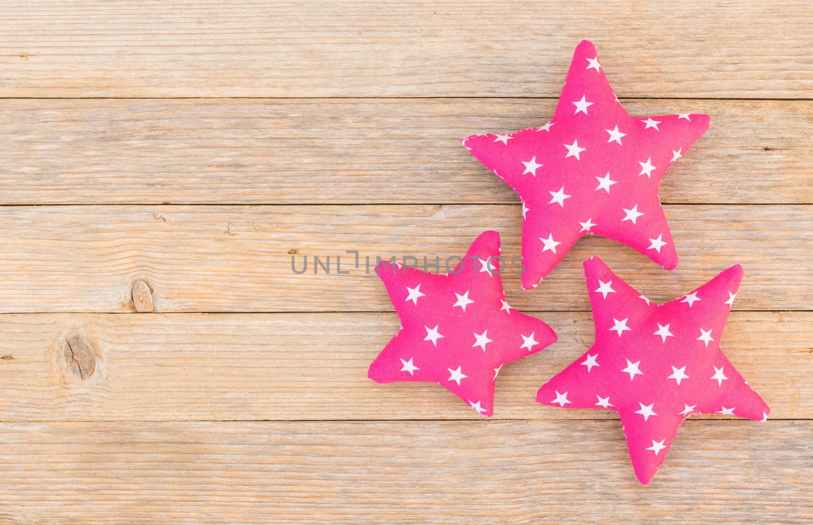Three fabric stars on wood background with copy space