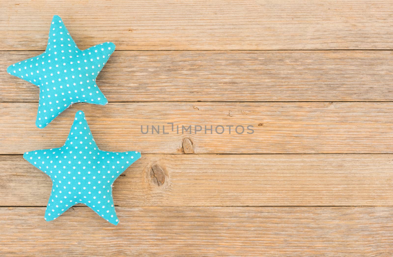 Blue fabric stars on wooden background with copy space