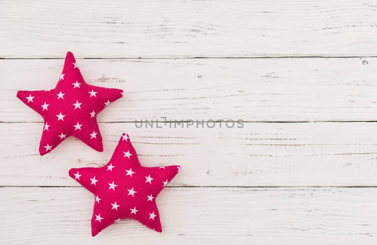 Pink fabric stars decor on white wooden background with copy space