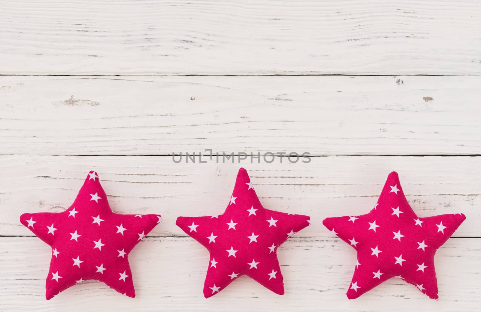 Pink fabric stars decor on white wooden background with copy space