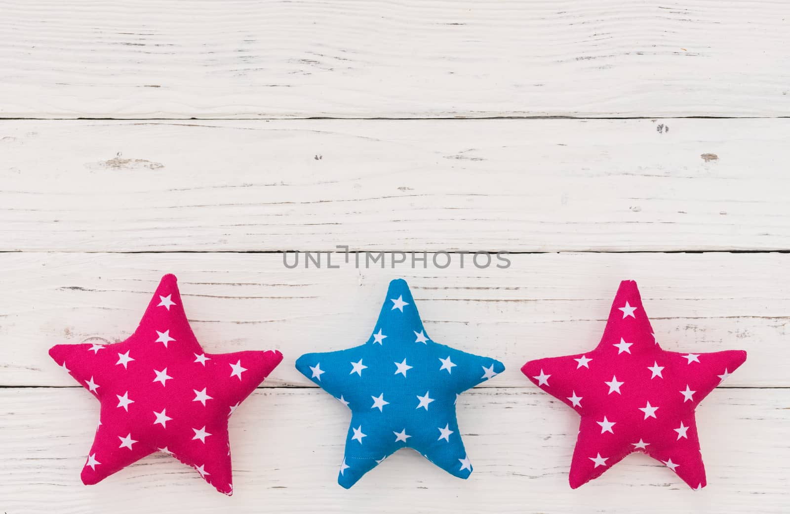 Fabric stars decor on white wooden background with copy space