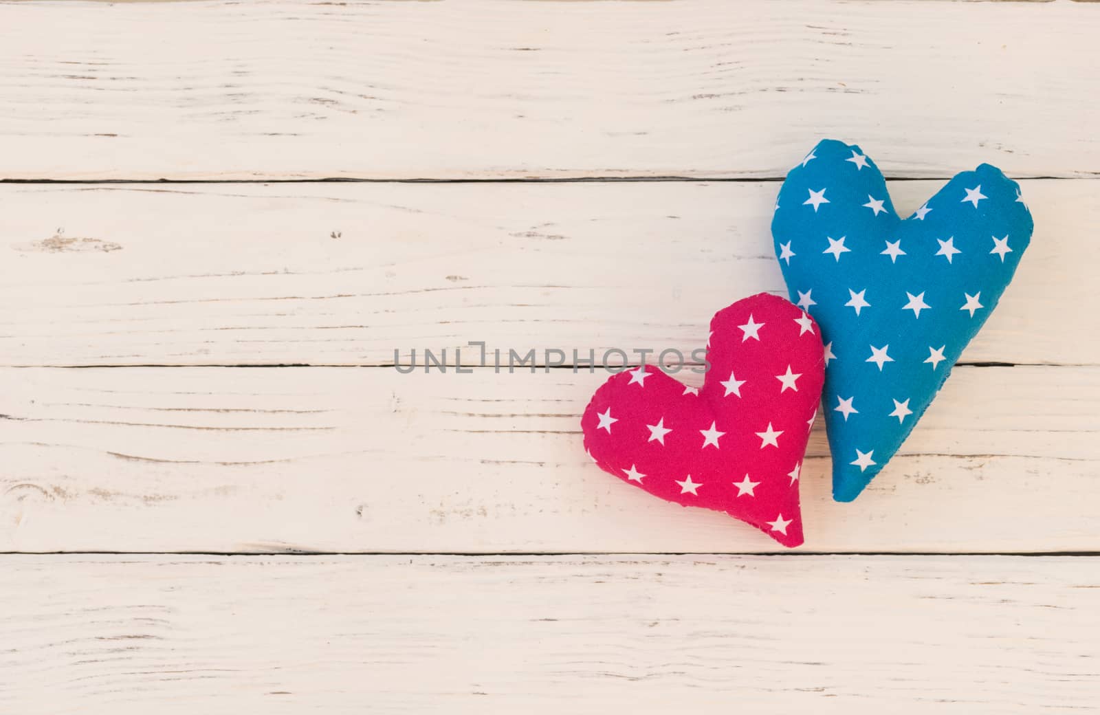 Two love hearts on white wooden background with copy space