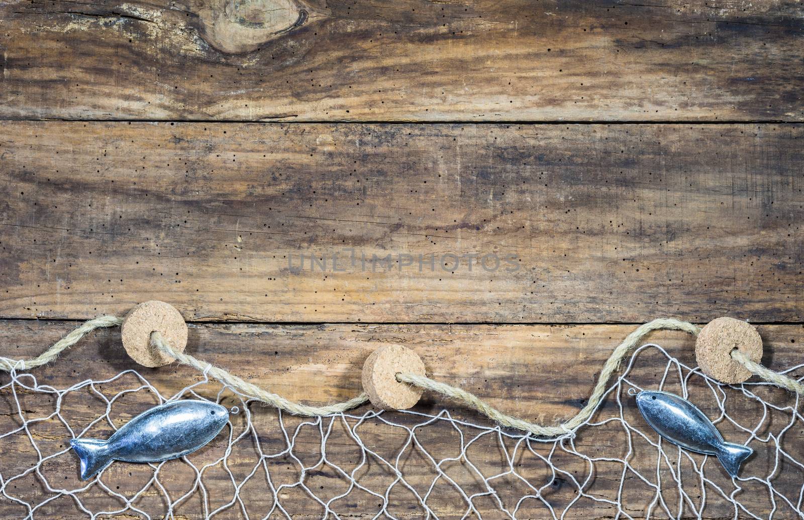 Fishing net background with fish decoration on rustic brown wood with copy space