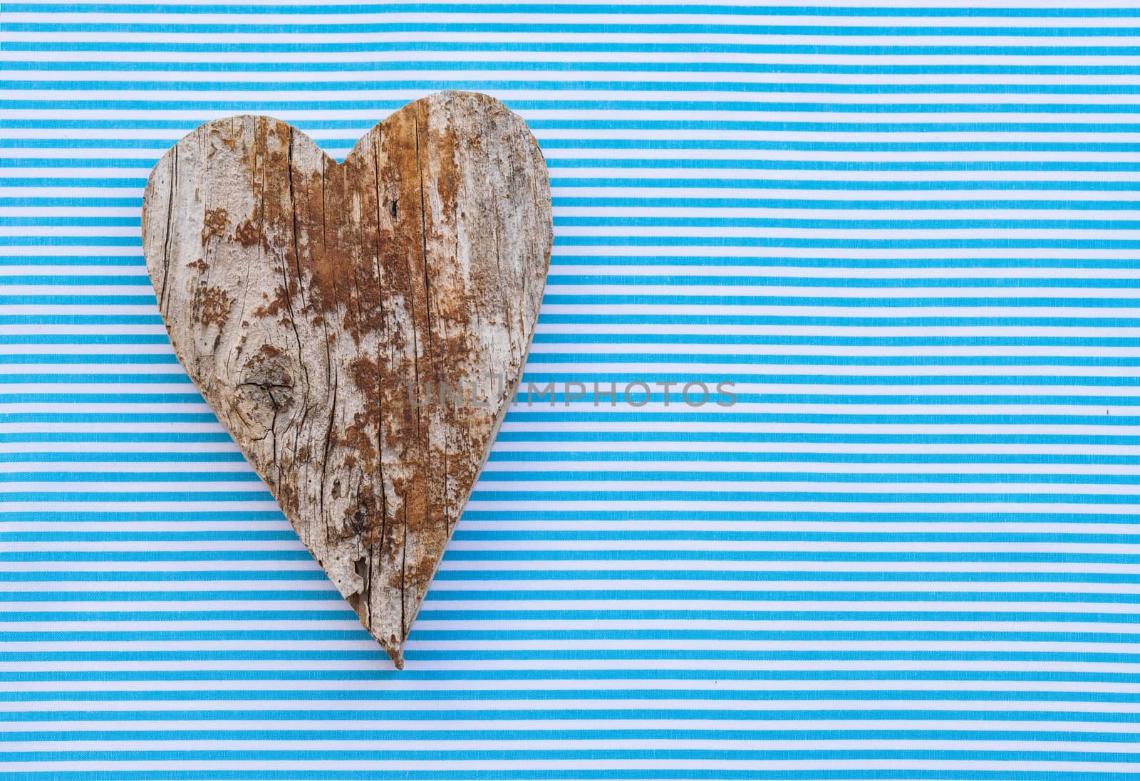 Rustic wooden heart on blue background by Vulcano