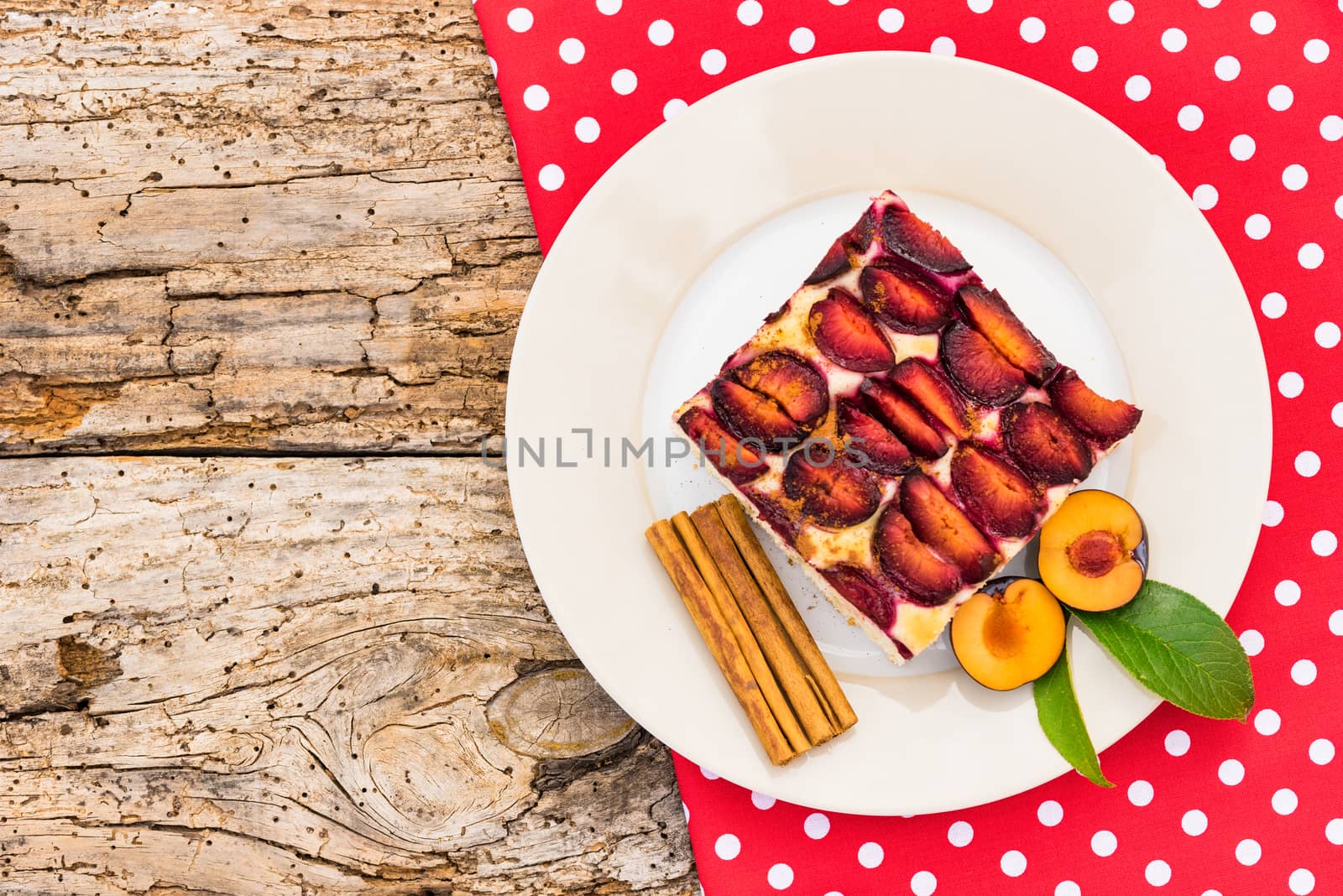 Piece of plume cake on plate on rustic wooden table background, top view
