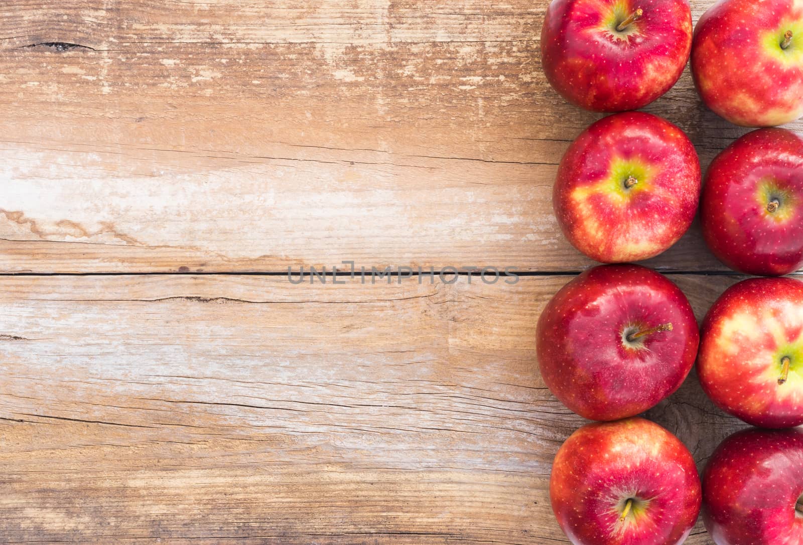Juicy red apple fruits on rustic wood background with copy space