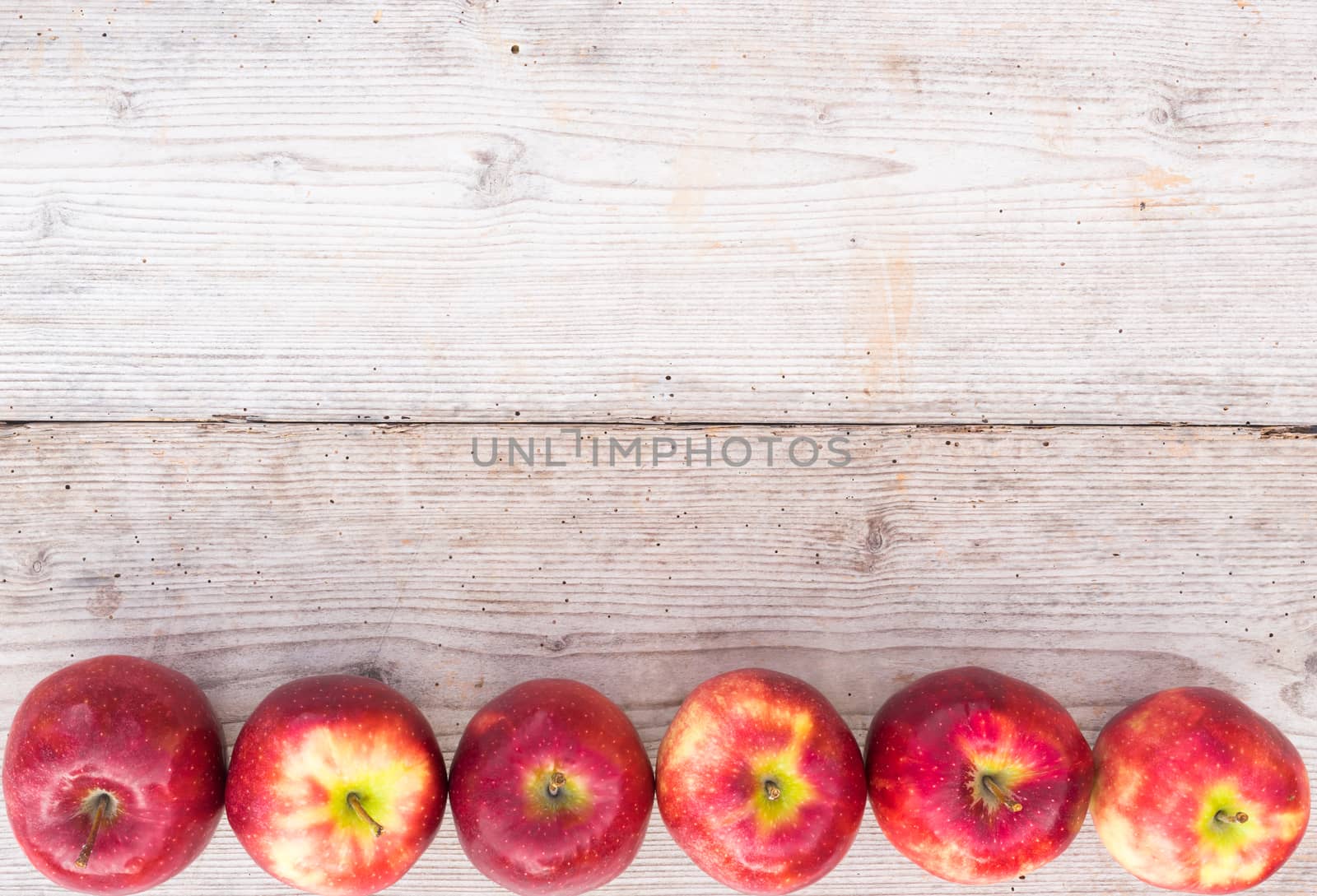 Apples background with juicy red fruits on wood, top view with copy space