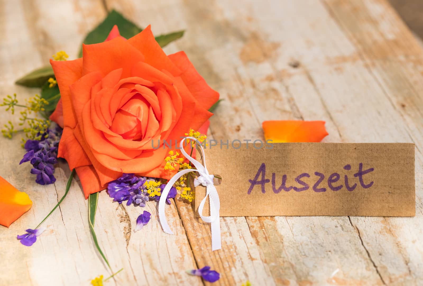 Flowers with gift card, voucher or coupon with german word, Auszeit, means timeout

