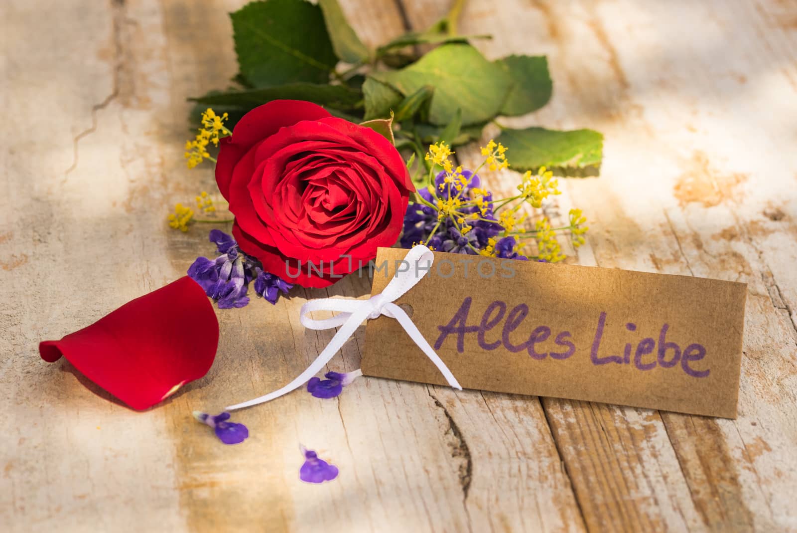 Bunch of flowers for Valentine day and tag with german text, Alles Liebe, means love