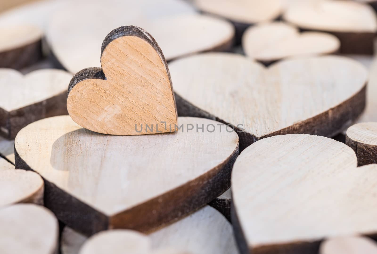 Romantic love background with close-up of many wooden hearts