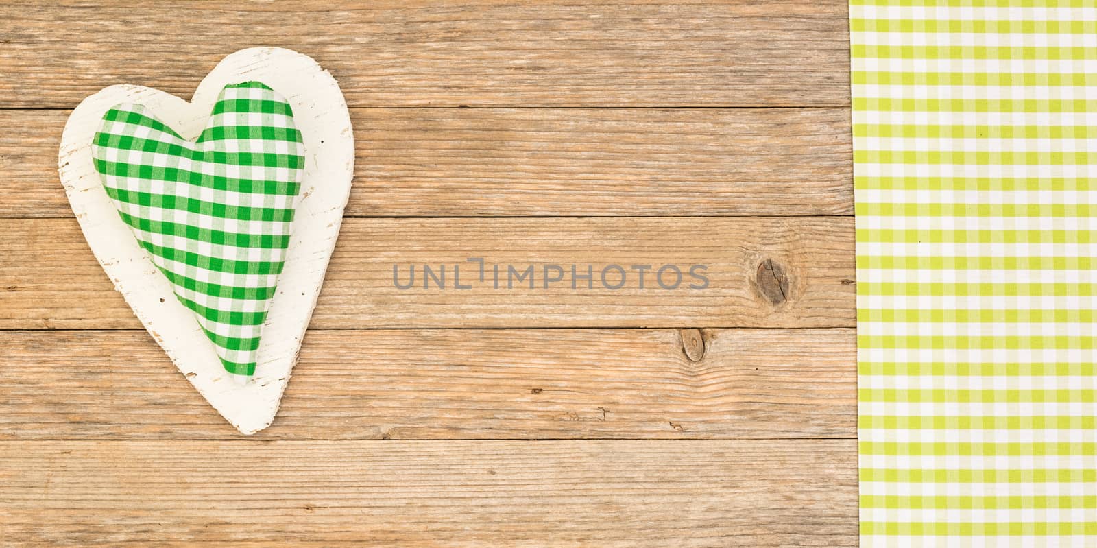 Green heart on wooden background with copy space