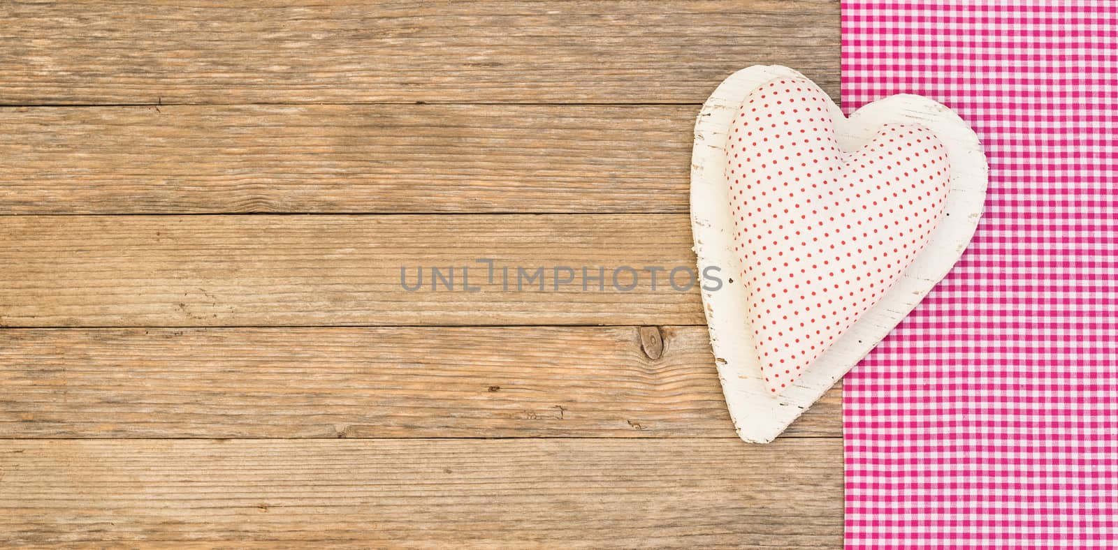 Romantic background with fabric heart on wood with copy space